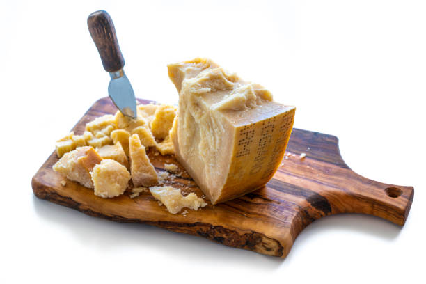 Parmesan Reggiano cheese on cutting board knife isolated on white background