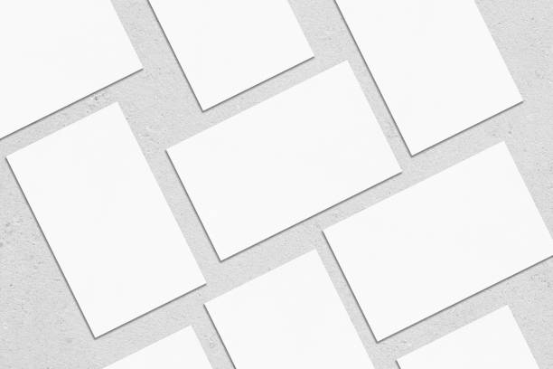 istock empty white rectangle business card mockups lying diagonally on neutral grey concrete background 1203731710
