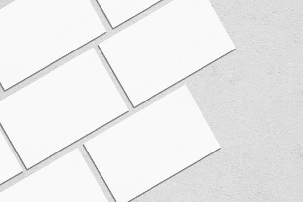 istock empty white rectangle business card mockups lying diagonally on neutral grey concrete background 1203731746