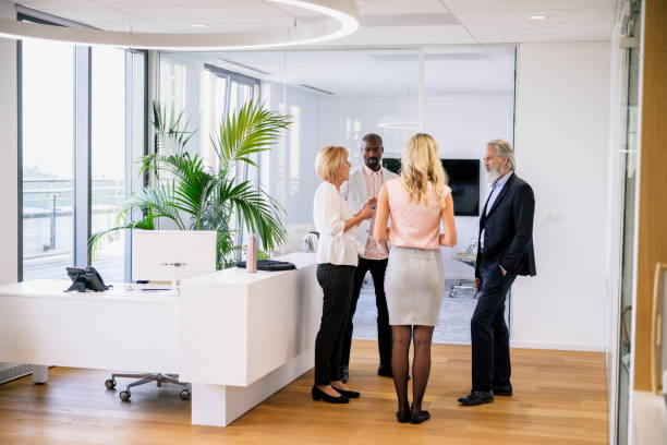 istock Diverse corporate colleagues conversing in office lobby 1203732813