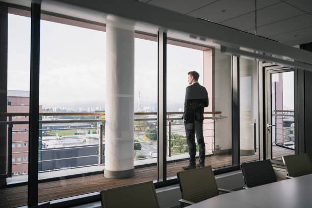 istock Contemplative businessman looking at view from office deck 1203732818