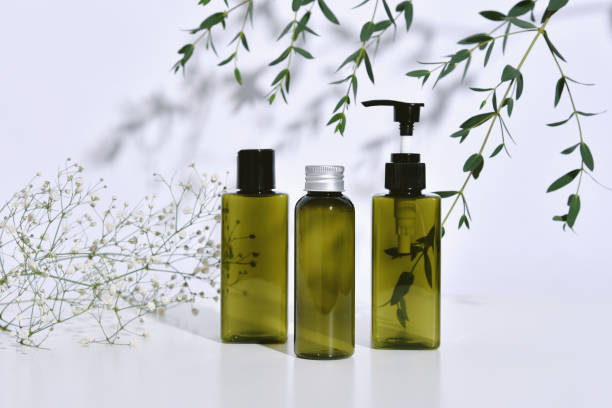 istock Cosmetic bottle containers packaging with green herbal leaves in shadow and light effect, Blank label for organic branding mock-up, Natural skincare beauty product concept. 1203733135