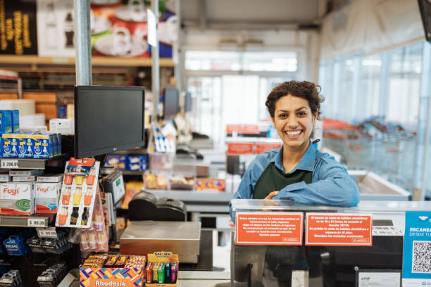 weibliche latina kassiererin im supermarkt - sales clerk store manual worker retail stock-fotos und bilder