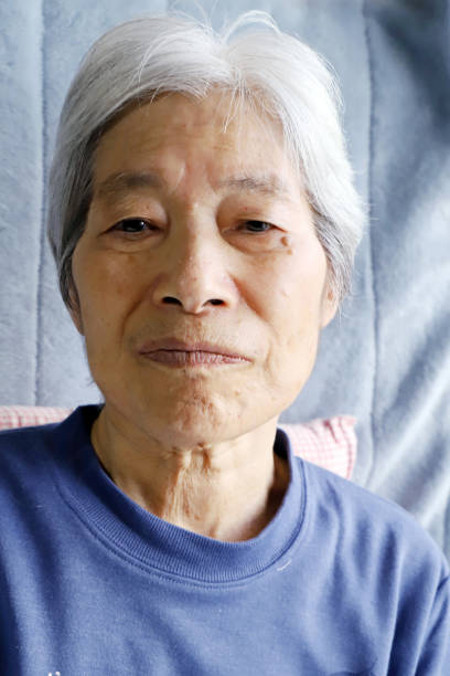 istock Senior lady sitting on the nursing bed and staring this way 1203733580