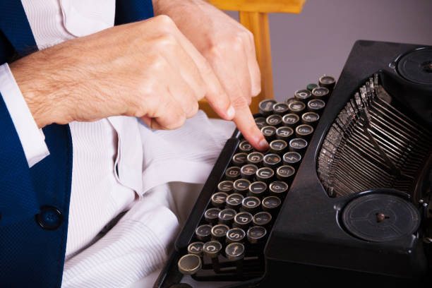 istock Close-up of man writing on typewriter. 1203735157