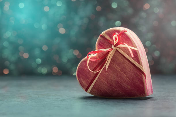 istock Red heart shaped gift box over holiday defocused light. Valentines day background 1203736431