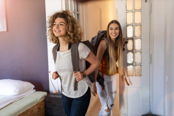 Young women with backpacks arriving to a youth hostel Young women with backpacks arriving to a youth hostel dorm room photos stock pictures, royalty-free photos & images