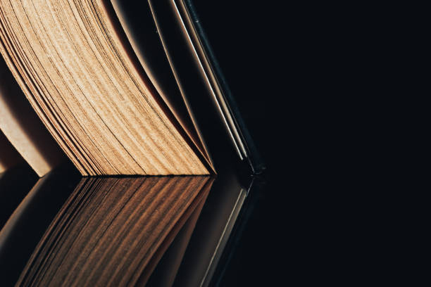 istock Beautiful ancient book pattern background for design. The book on a  black glass table  background. 1203740615