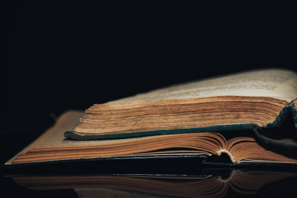 istock Beautiful ancient book pattern background for design. The book on a  black glass table  background. 1203740686