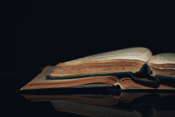 istock Beautiful ancient book pattern background for design. The book on a  black glass table  background. 1203740728
