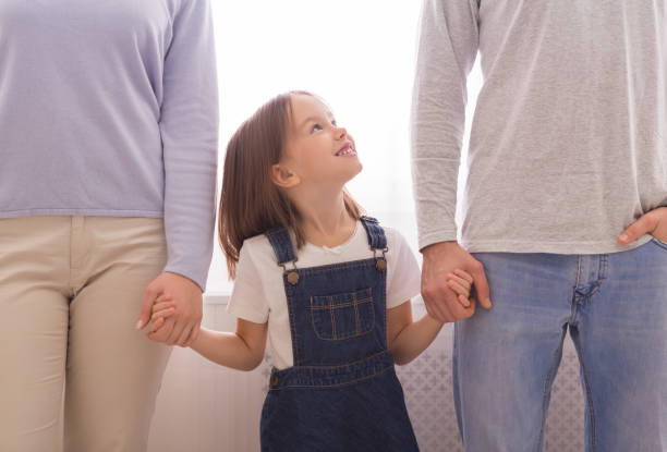 happy little girl holding hands with parents and looking at father - human hand child abstract adult imagens e fotografias de stock