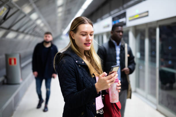 istock Female passenger with phone waiting for subway train 1203740979