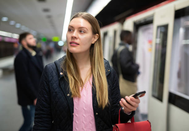 istock Female passenger with phone waiting for subway train 1203741153