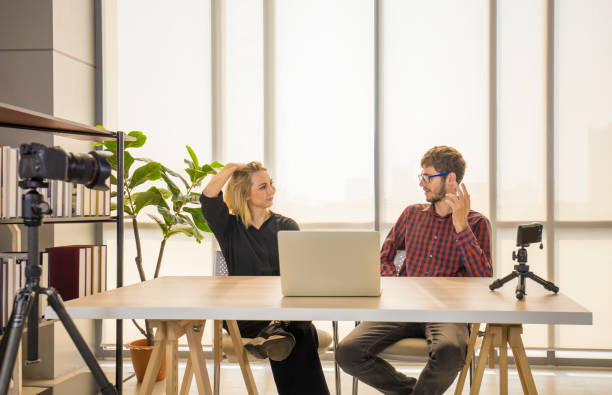 istock Two young content creators discussing while filming themselves live stream on making online vlogging show 1203741165