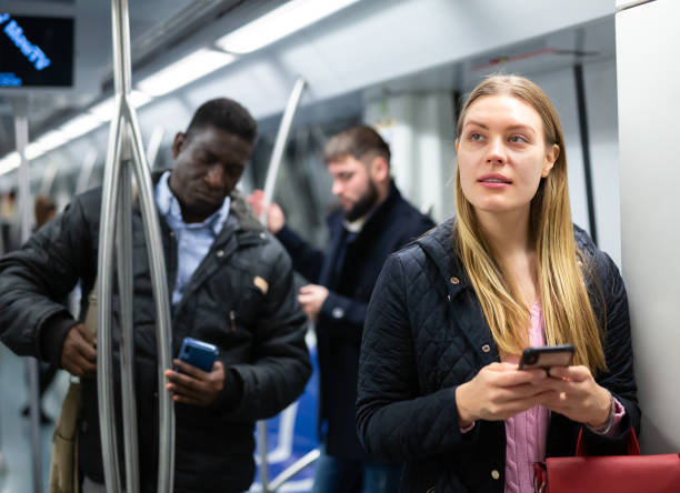 istock Girl using mobile phone in metro car 1203741167