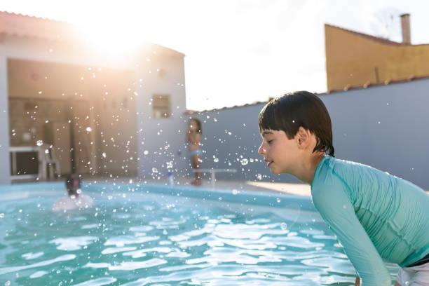 istock Boy jumping in the pool 1203744023