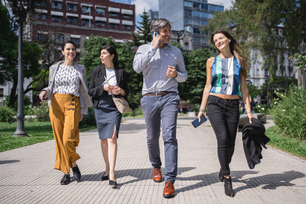 istock Carefree business people walking in a park after work 1203745774