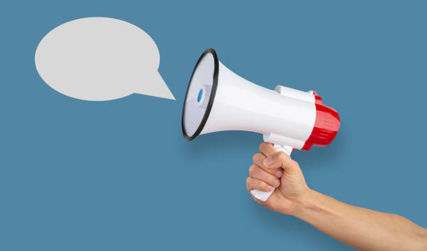 istock Announcement. Hand holding megaphone. 1203746548