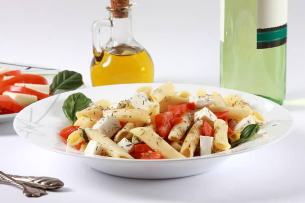 penne di grano duro con pomodori e mozzarella - mozzarella tomato salad italy foto e immagini stock