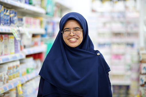 Portrait of Muslim female pharmacist in pharmacy.