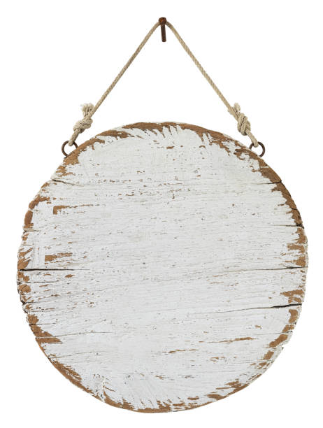 istock Old weathered worn white circular wooden board sign panel, hanging by old rope from a rusty nail, isolated on white, clipping path included. 1203749558