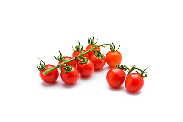 Bunch of cherry tomatoes isolated on reflective white background Bunch of cherry tomatoes isolated on reflective white background. Predominant colors are red and white. High resolution 42Mp studio digital capture taken with Sony A7rii and Sony FE 90mm f2.8 macro G OSS lens cherry tomato stock pictures, royalty-free photos & images