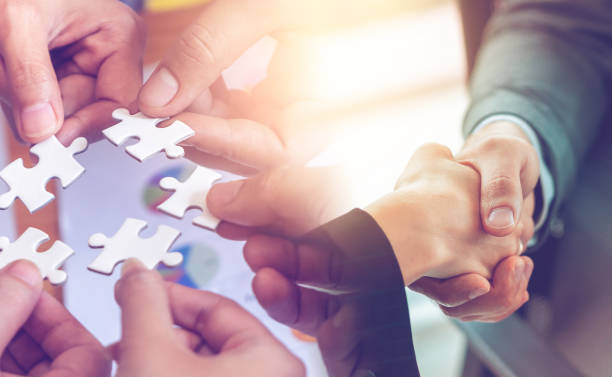 istock Business team strategy concept with jigsaw and handshaking for business team solution success concept 1203749944