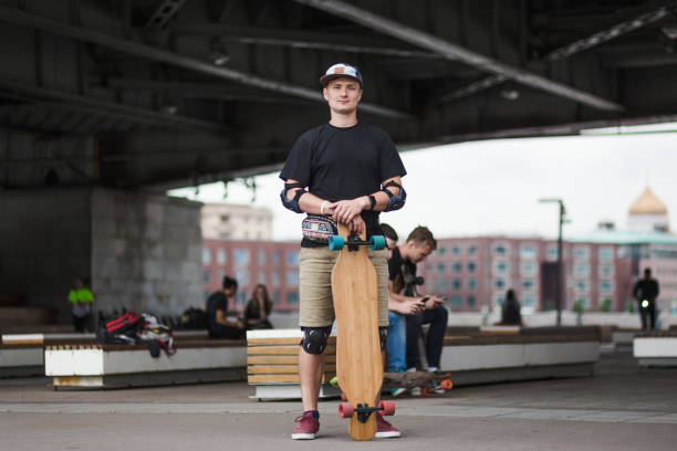 istock Urban young man with his wooden longboard 1203751829
