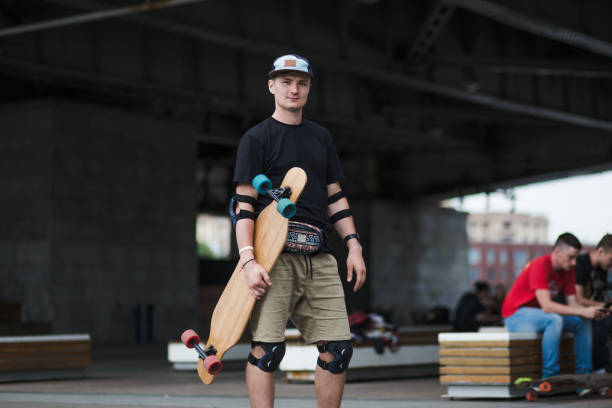 istock Male skater with longboard under the bridge 1203751963