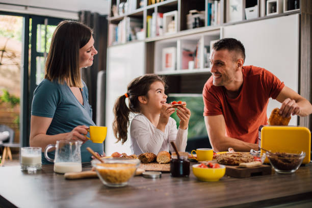 glad familj njuter av sin frukost på helgen morgon - breakfast bildbanksfoton och bilder