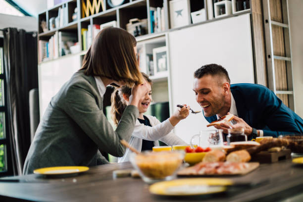 istock Girl feeding her dad and having fun during breakfast 1203756182