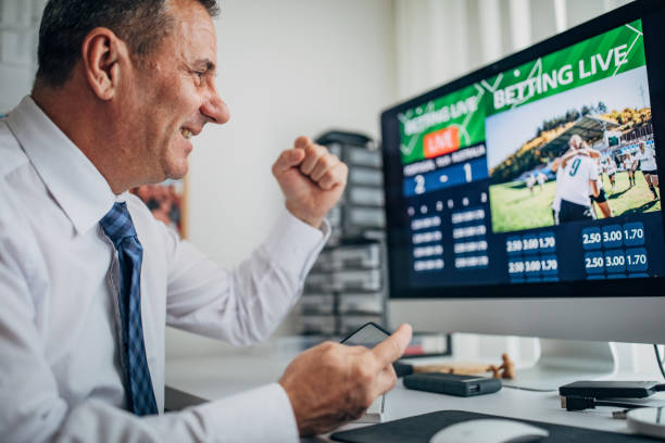 istock Business man using computer and smart phone for live betting in office 1203756377