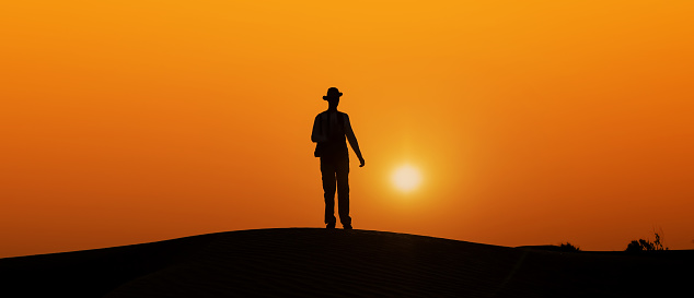 safari desert photographer black silhouette body in the evening sun arabian sand dunes