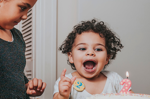 Stock photo of a little girl who is blowing her 2 years old birthday candle.