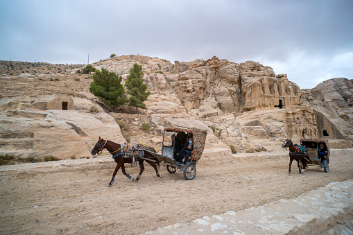 PETRA, JORDAN - 26 October 2018: Carriage with passengers ride in Al Siq passage to ancient Petra town.