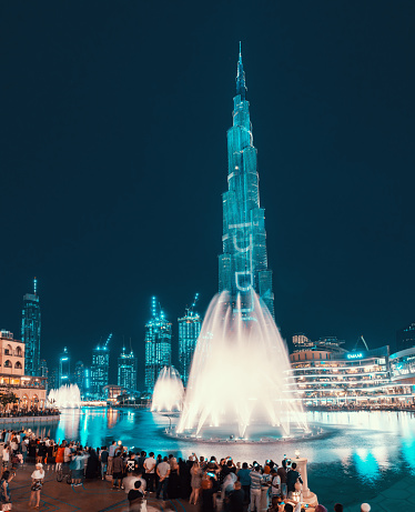28 November 2019, UAE, Dubai: Evening view of the illuminated tower of Burj Khalifa and a pond with a dancing fountain. Popular and majestic show in Dubai