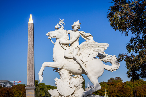 Mercury straddling Pegasus statue and Obelisk of Luxor in Concorde square, Paris, France