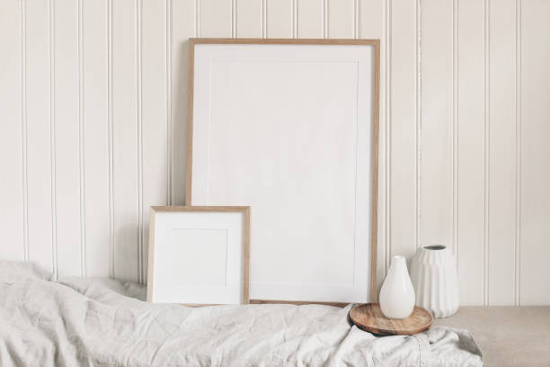 istock Portrait and square empty wooden frame mockups with linen cloth and modern ceramic vases. White beadboard wainscot wall paneling background. Scandinavian interior, home design. Art concept. 1203759599