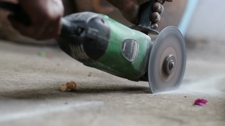 Mechanic hands are cutting concrete with tools.
