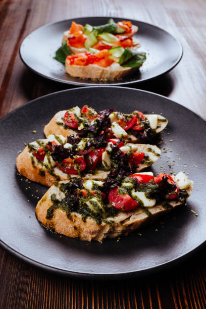 istock Italian Appetizer Bruschetta with roasted tomatoes, mozzarella cheese, garlic and herbs 1203762264