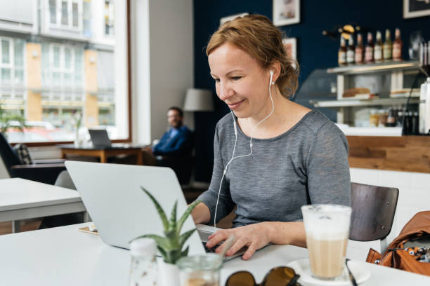 istock Woman Listening To Music While Working In Small Cafe 1203762862