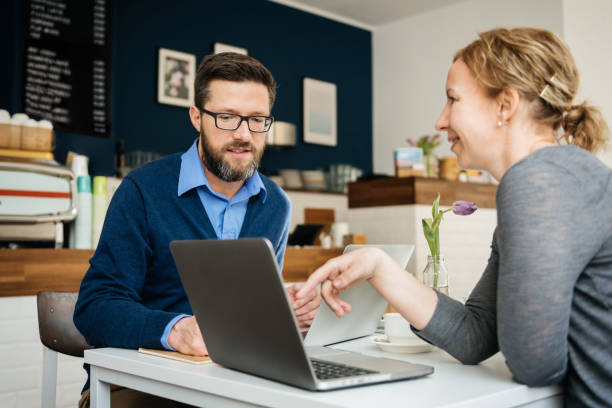 istock Two Business Partners Talking In Small Cafe 1203762871