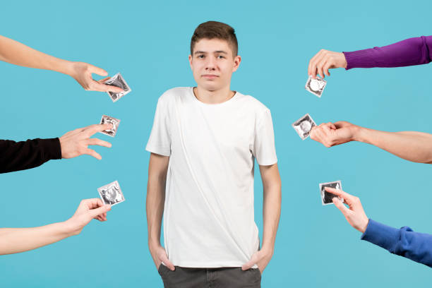 un adolescent dans un t-shirt blanc regarde incertain en avant - teenage sex photos et images de collection
