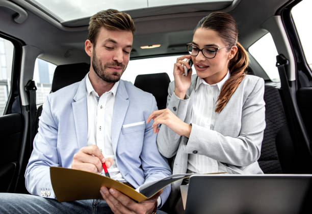 istock Young business people working together while traveling by a car. 1203763825