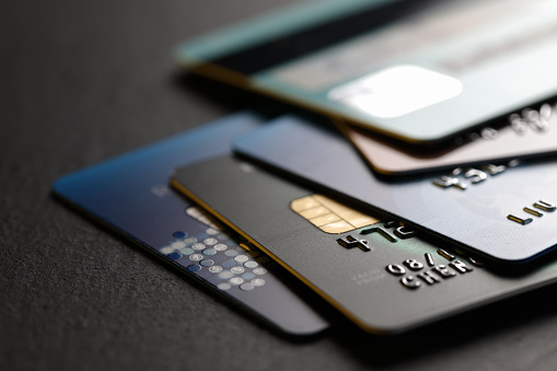 stack of multicolored credit cards on black background