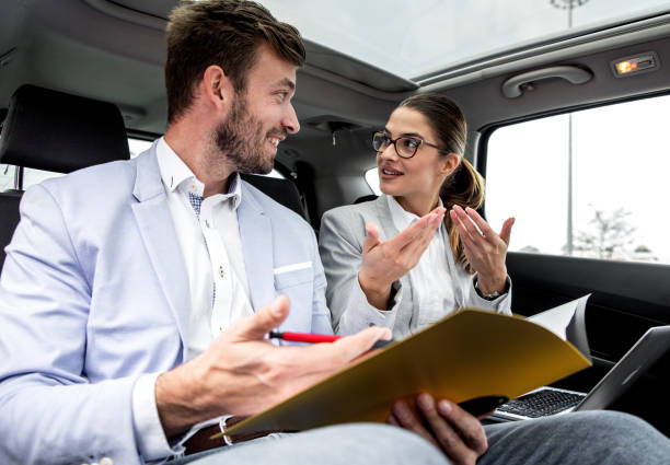 istock Young business people working together while traveling by a car. 1203764361
