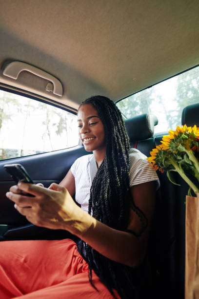 istock Texting woman in car 1203764816