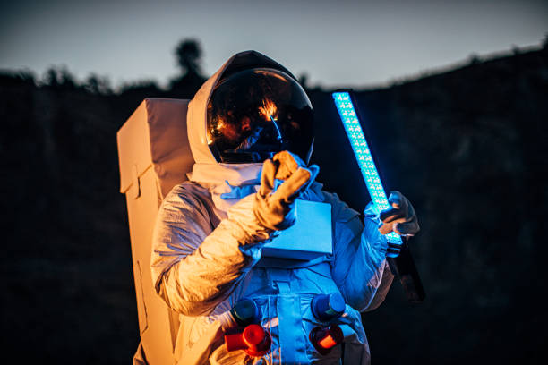 istock Astronaut with lamp and rock in hands exploring Mars 1203765827