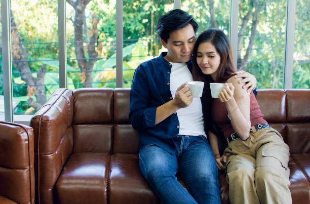istock Couple is holding cups of coffee 1203770045