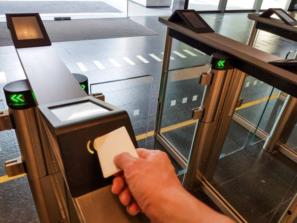 istock Men hand reaching to use RFID key card to access pass turnstile area. In building security only for authorized person. Technology in office workplace help to keep people and property safe and secure. 1203771973